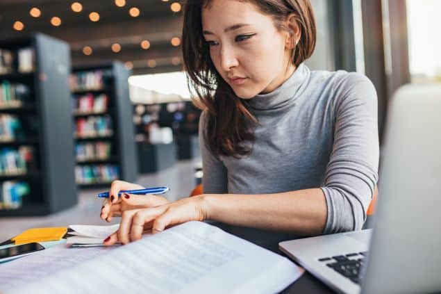 Female college student studies textbook