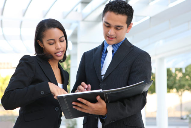 Colleagues looking at a notebook together